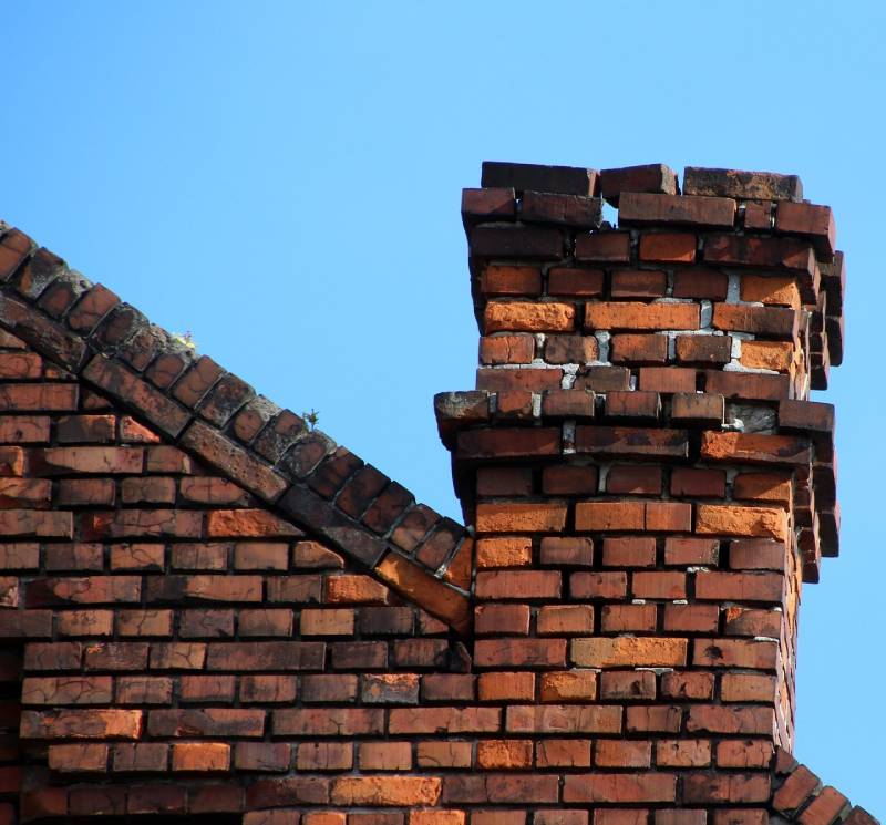 Damaged chimney on an Needham home showing cracks and missing mortar